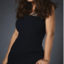 Salma Hayek in a black dress against a gray backdrop